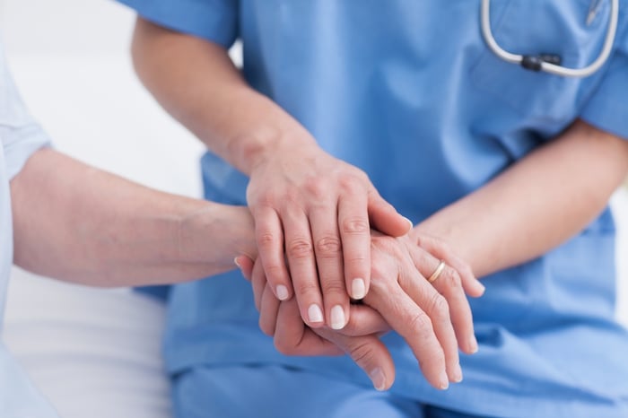 Close up of a nurse touching hand of a patient in hospital ward.jpeg